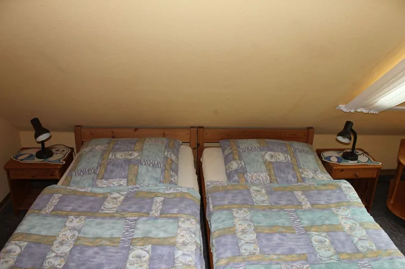 Kinderzimmer mit zwei Einzelbetten unter der Dachschräge