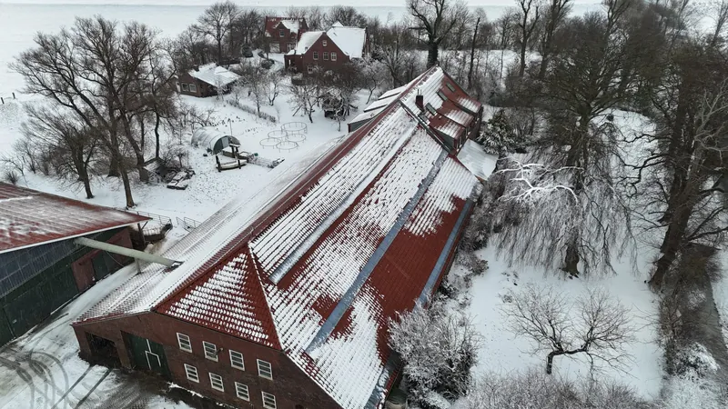 Das Gulfhaus mit dem Haupthaus im Schnee, schräg von oben