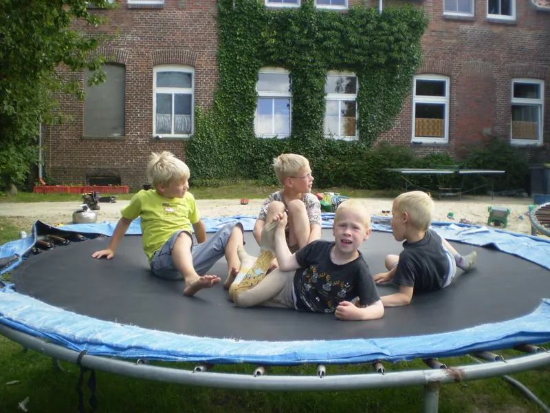 Kinder sitzen zusammen auf einem Trampolin