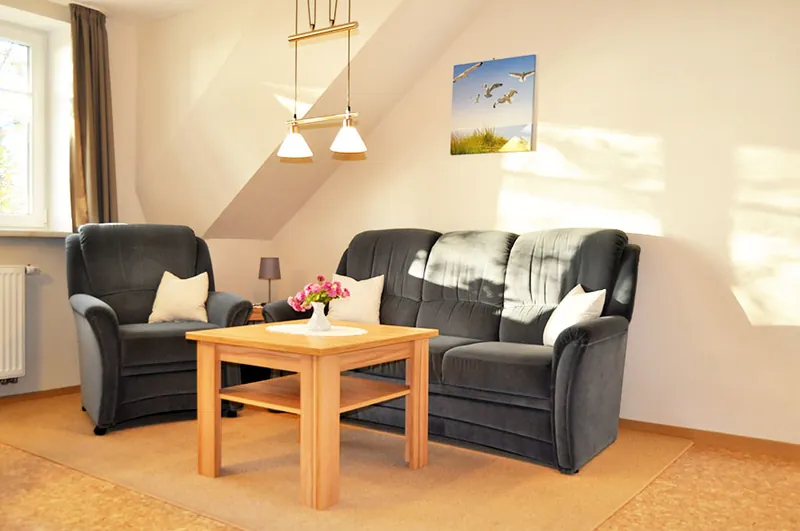 Wohnbereich mit Sitzgruppe und Couchtisch unter der Dachschräge