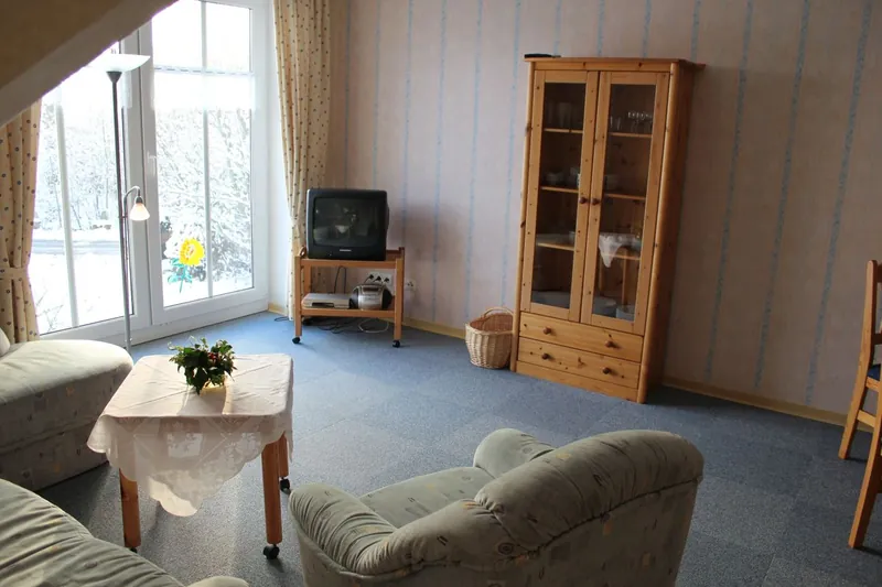 Wohnbereich der Ferienwohnung Juist mit Sitzgruppe und Terrassentür