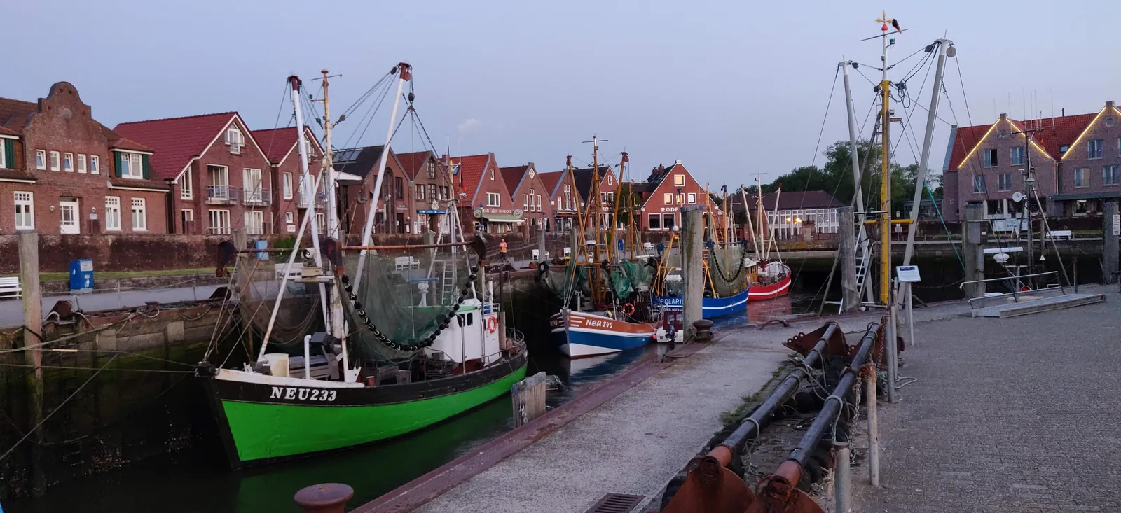 Hafen von Neuharlingersiel am Abend mit Krabbenkuttern vor den Giebelhäusern