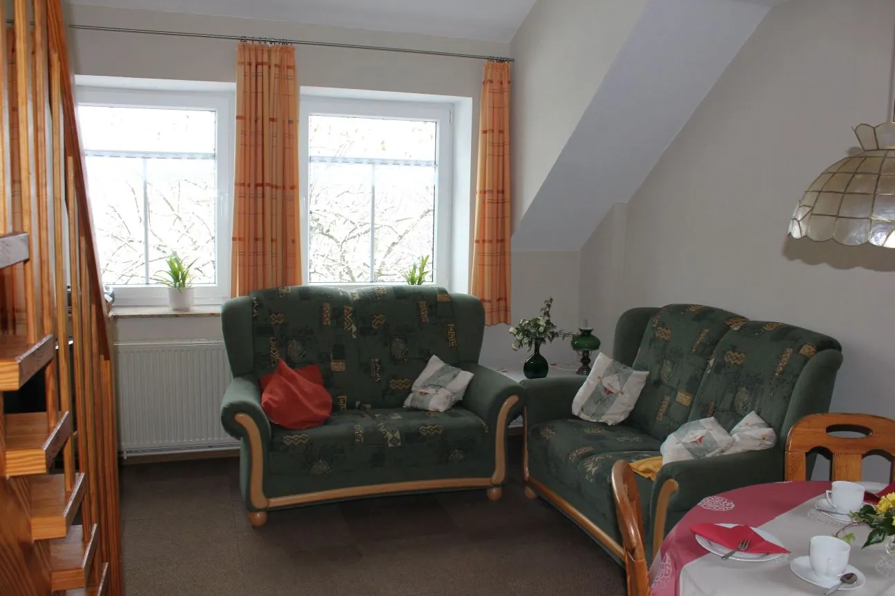 Wohnbereich der Ferienwohnung Neuharlingersiel mit zwei Sofas am Fenster
