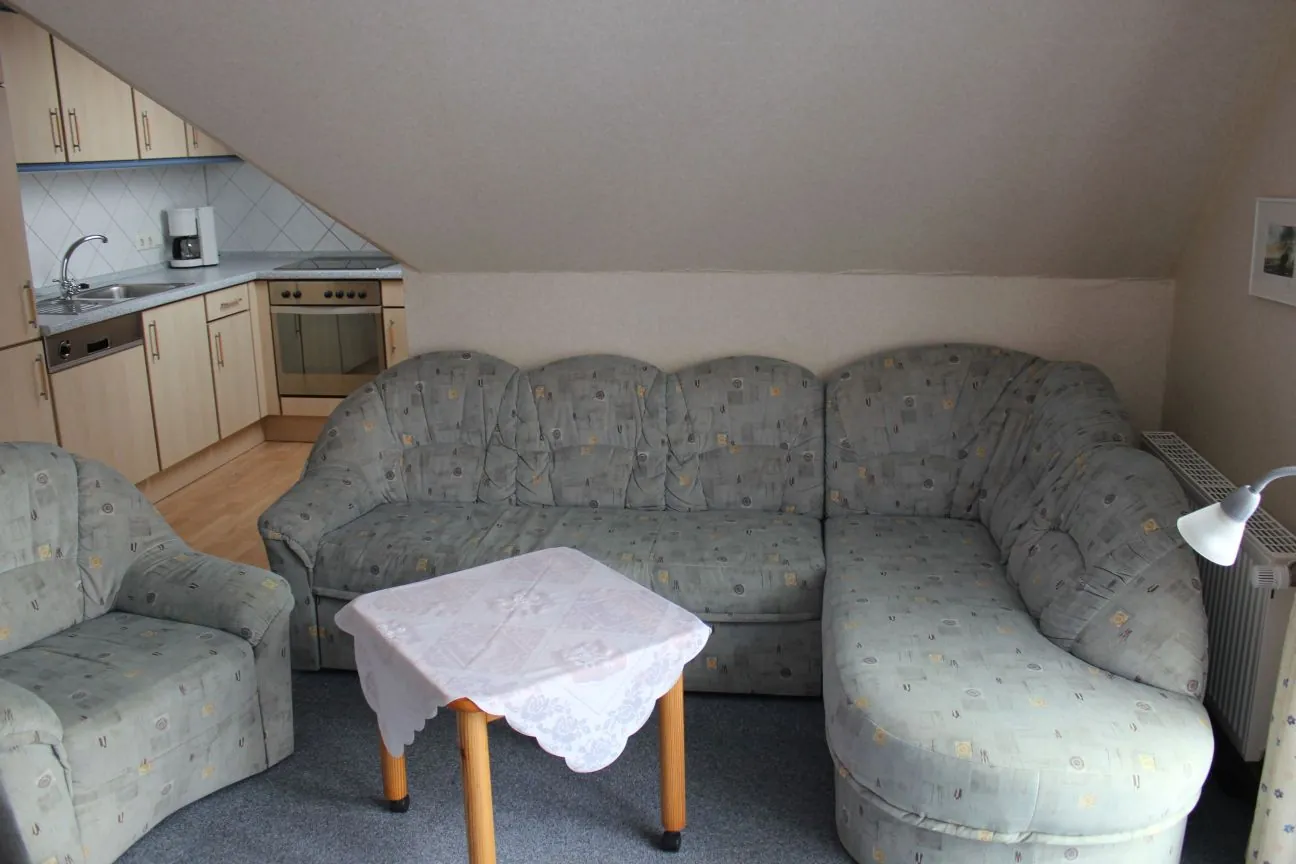 Wohnbereich der Ferienwohnung Norderney mit Ecksofa und offener Küche