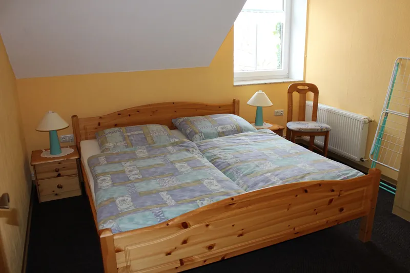 Schlafzimmer mit Doppelbett in hellem Gelb