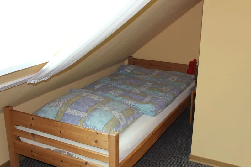 Einzelbett unter der Dachschräge im Kinderzimmer