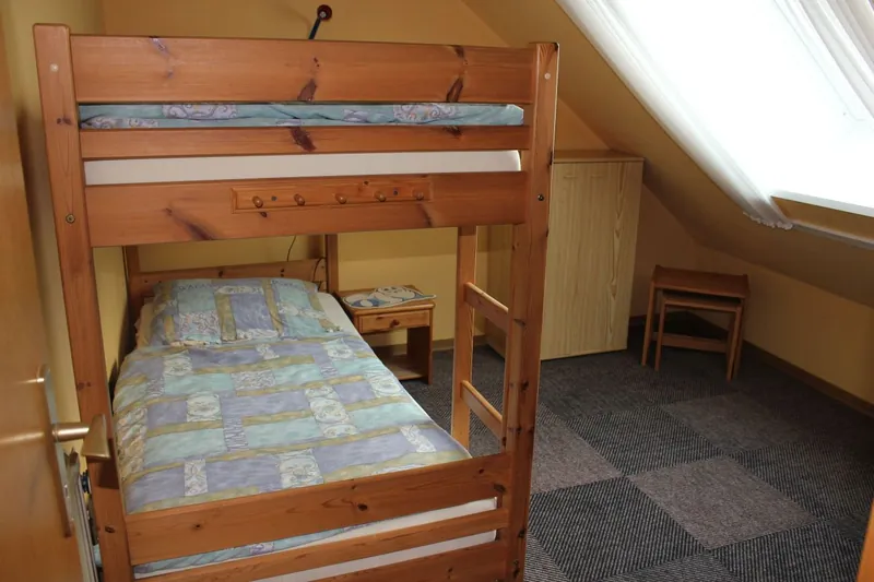 Kinderzimmer mit Etagenbett aus Holz unter der Dachschräge